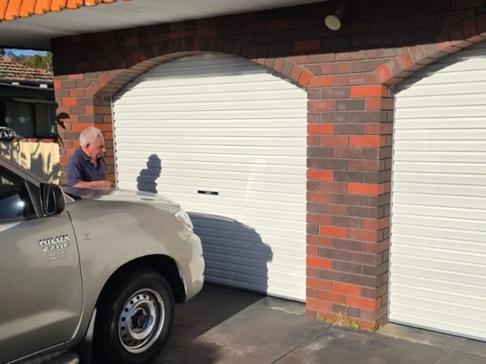 The same arched brick openings fitted with new white roller doors