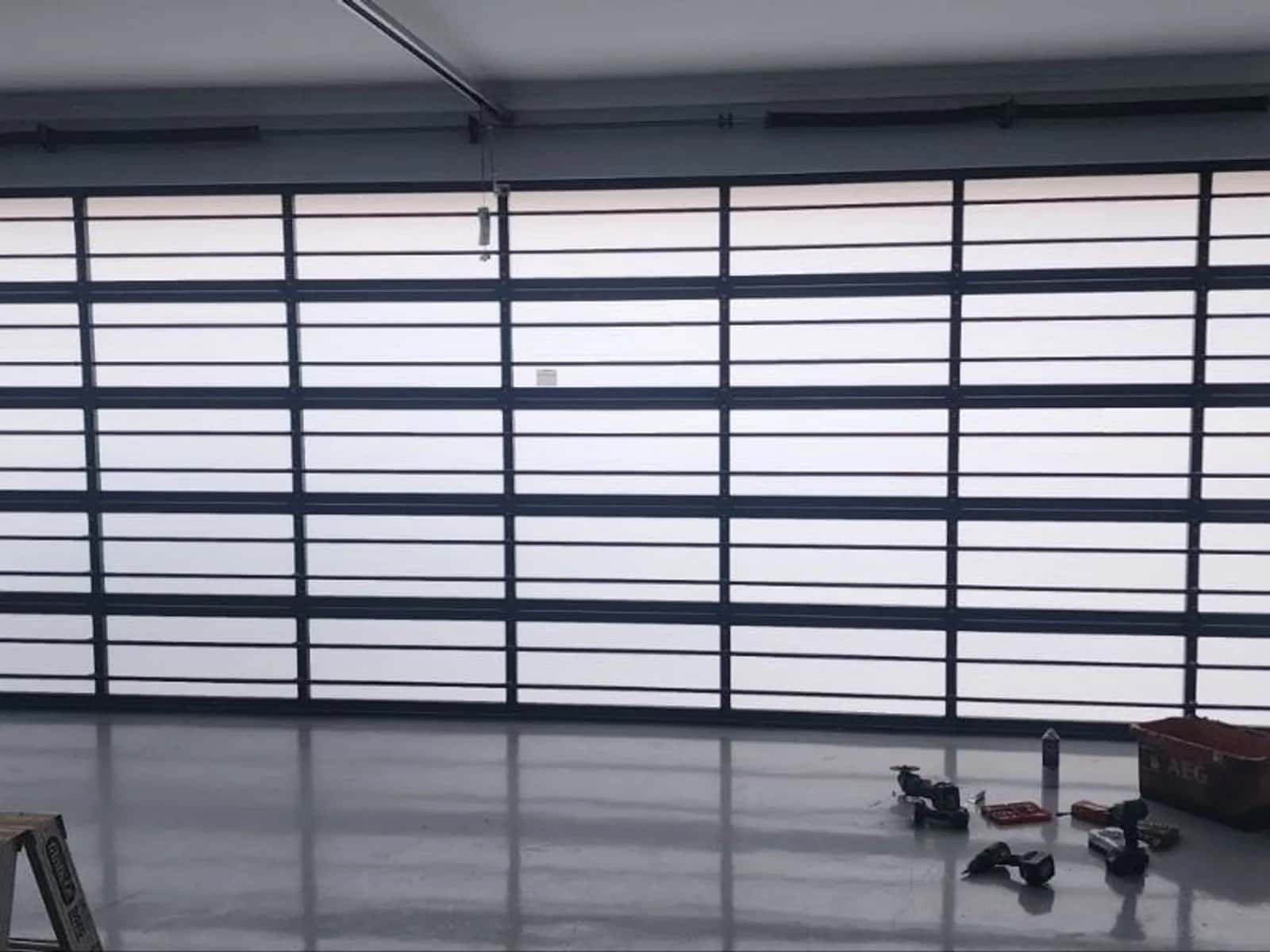 Aluminium-framed sectional garage door with glass panels on a Perth home