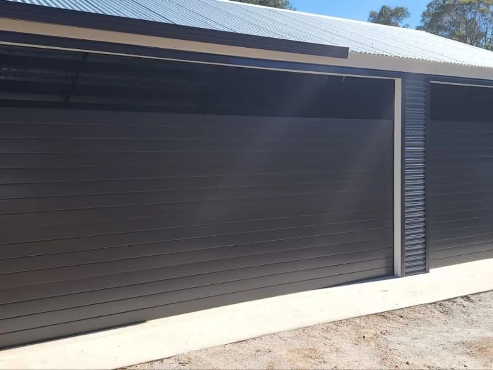 Two charcoal roller doors fitted side by side on a double shed Two charcoal roller doors fitted side by side on a double shed