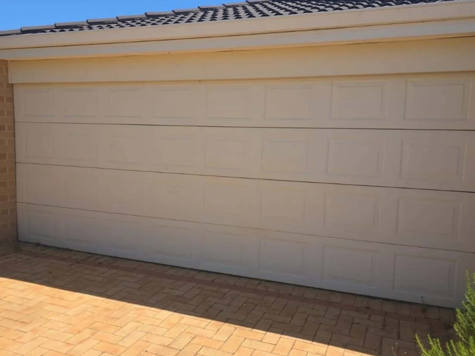 Cream raised-panel sectional garage door across a double garage in Thornlie, Perth
