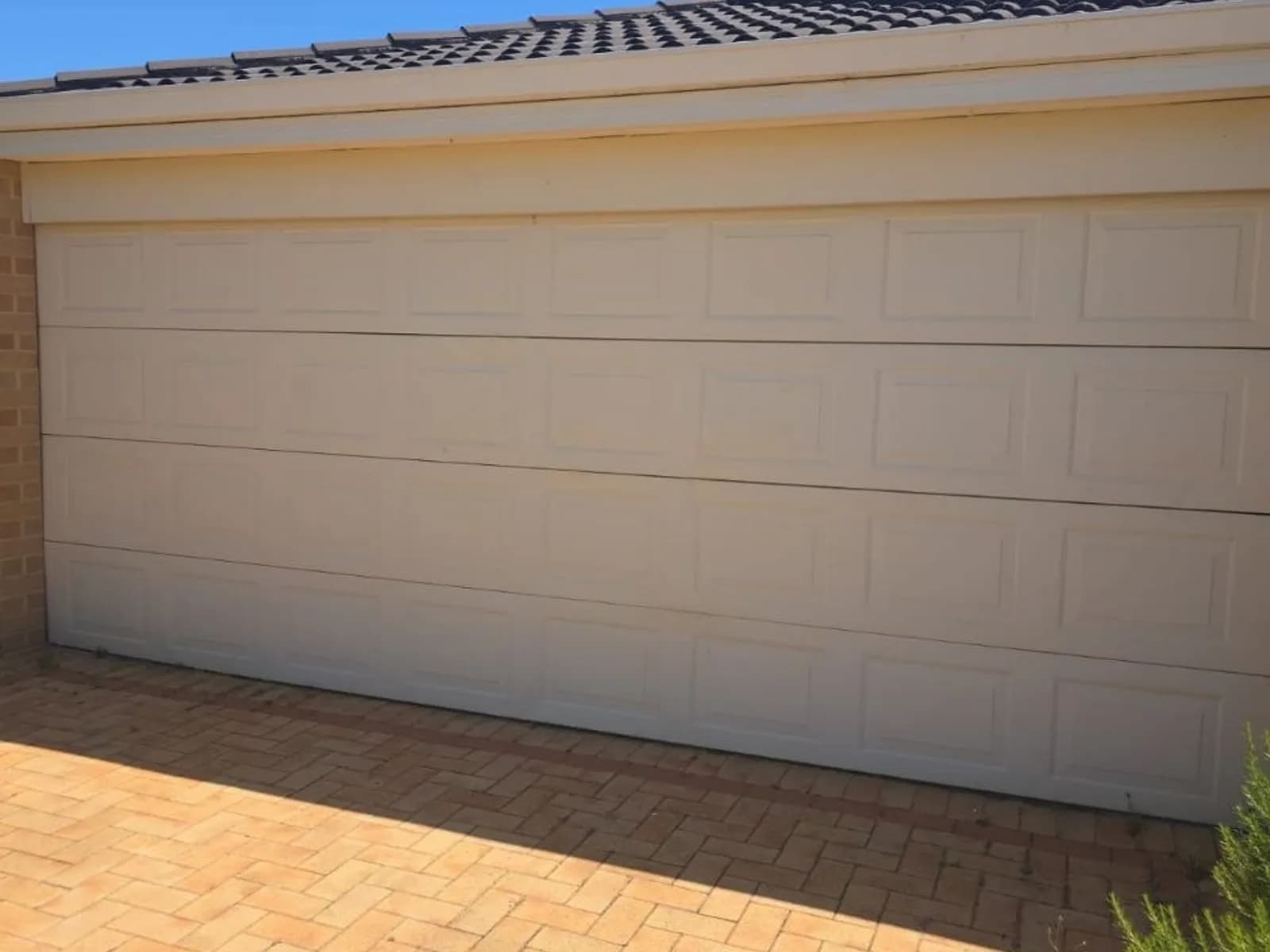 Cream panel-lift garage door on a brick home, the door style B&D Controll-A-Door openers are usually fitted to