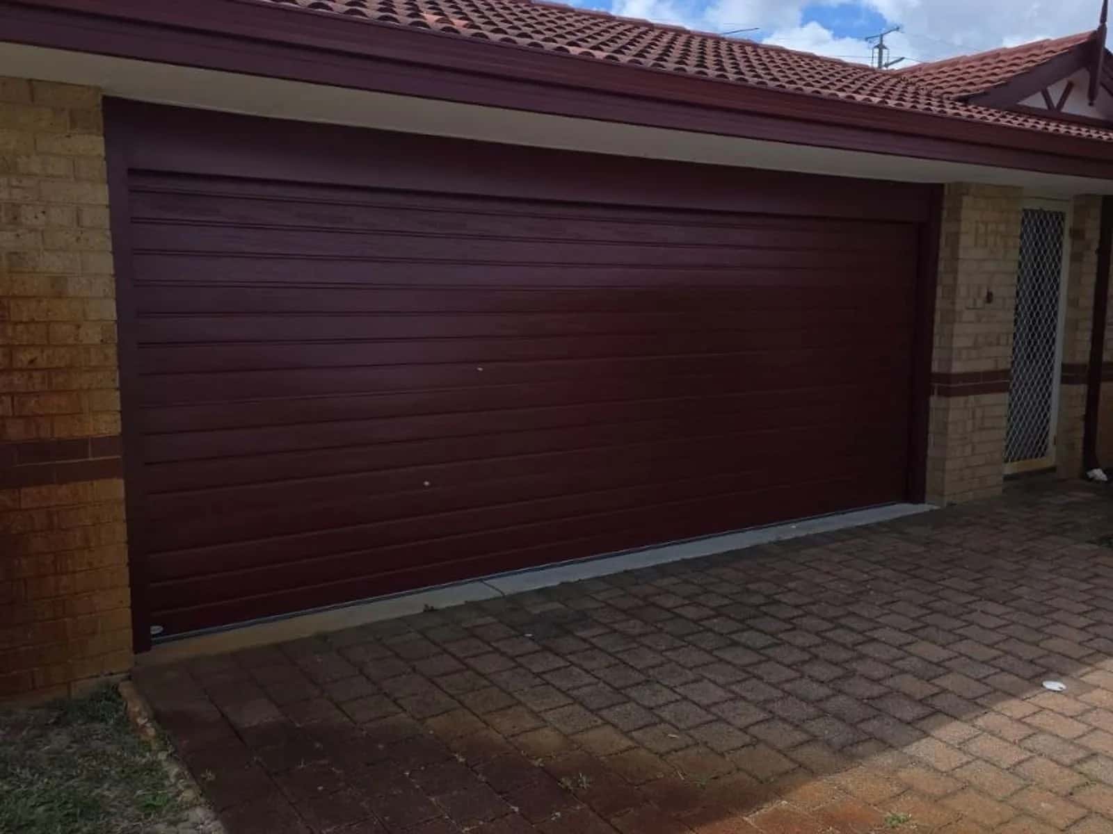 Maroon Colorbond roller door across a double garage