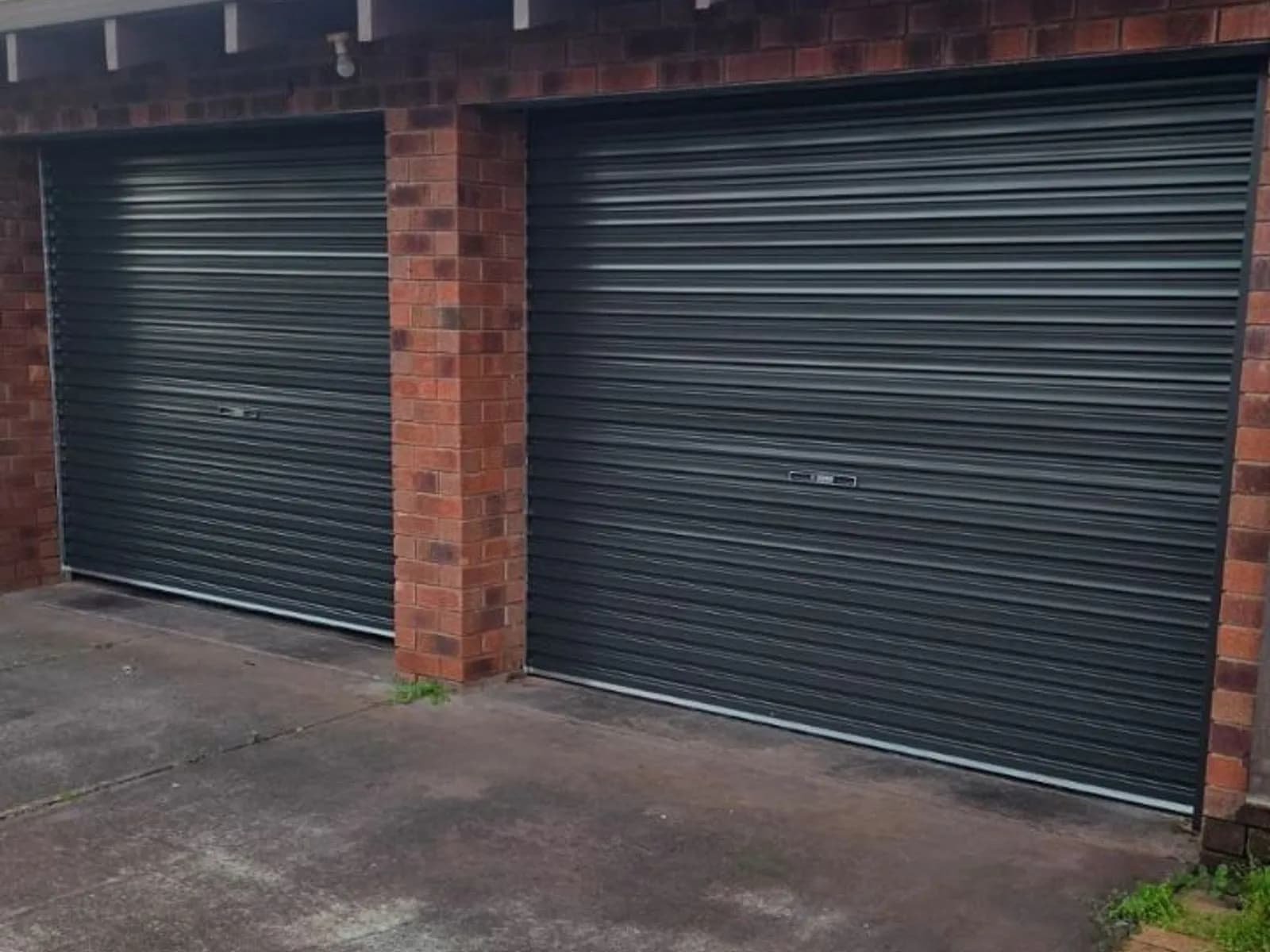 Two Monument-coloured COLORBOND roller doors side by side on a double garage