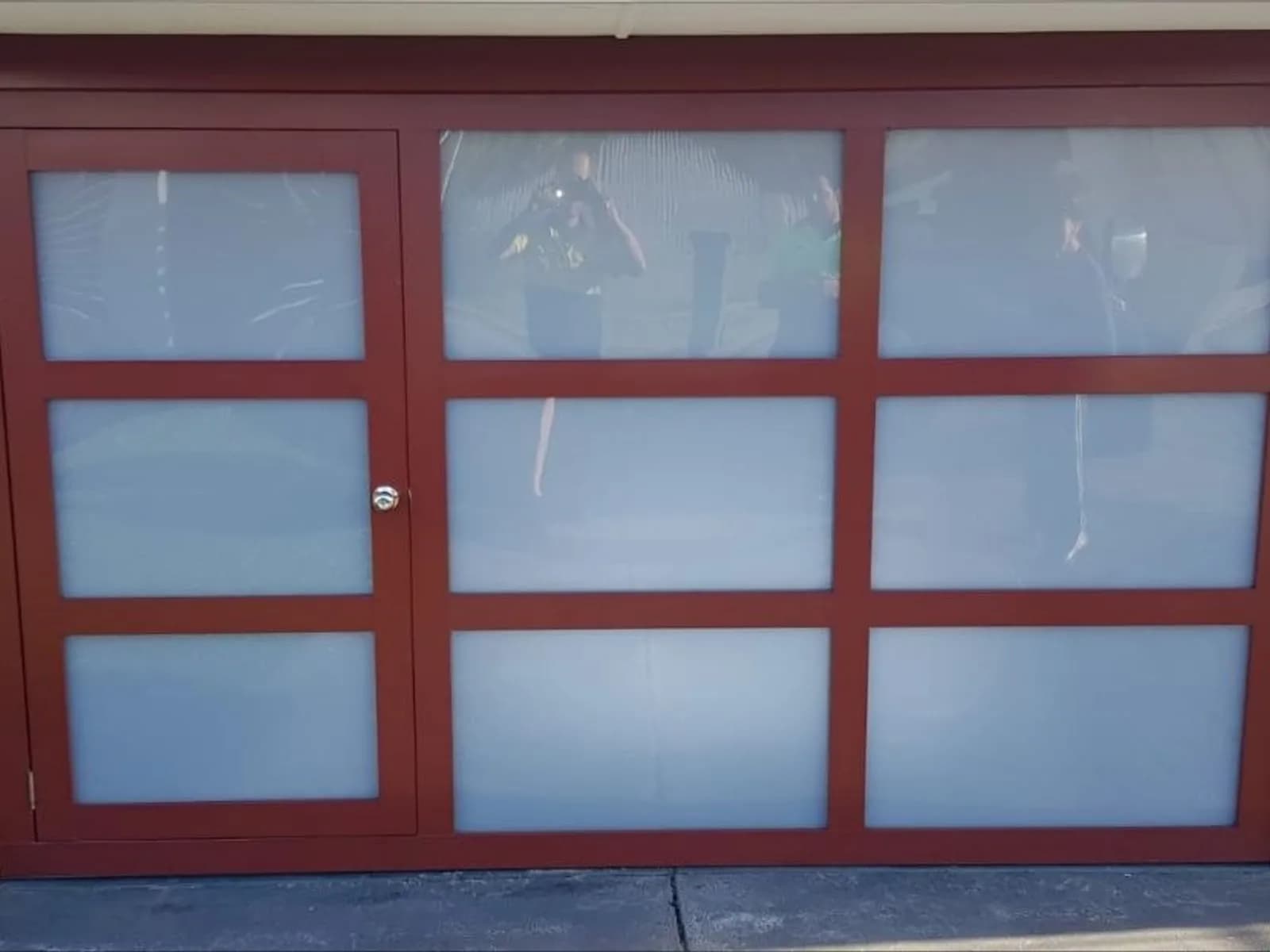 Red-framed sectional garage door with full-height glass panels on a Perth home Red-framed sectional garage door with full-height glass panels on a Perth home