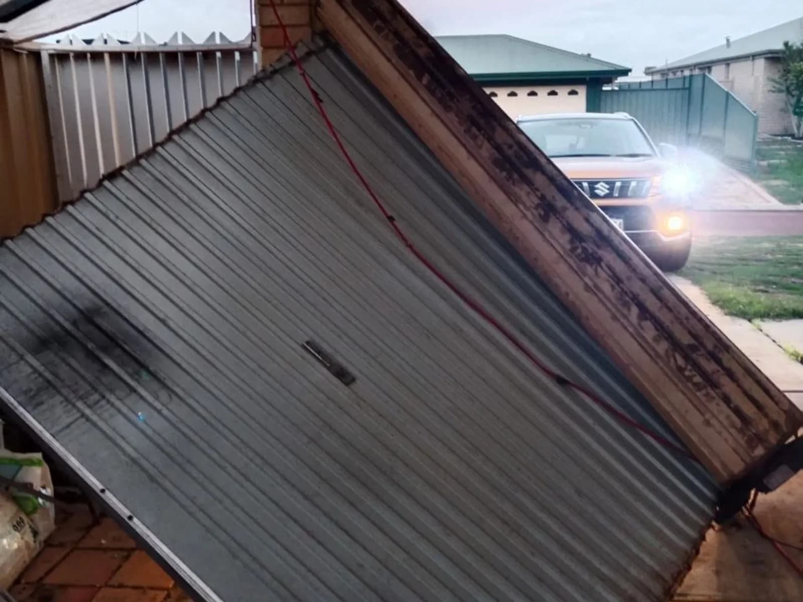 Roller door curtain sitting out of its side guide before repair