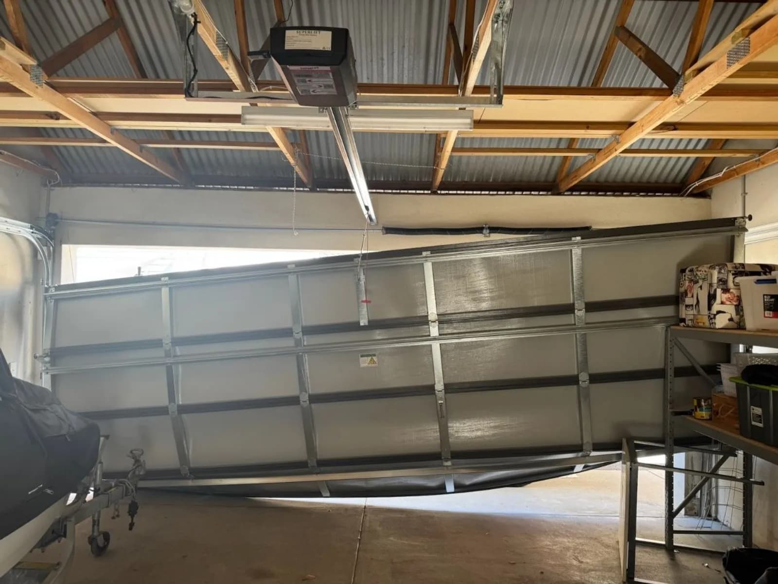 Ceiling-mounted garage door opener above a sectional door, the head unit where a backup battery pack is fitted