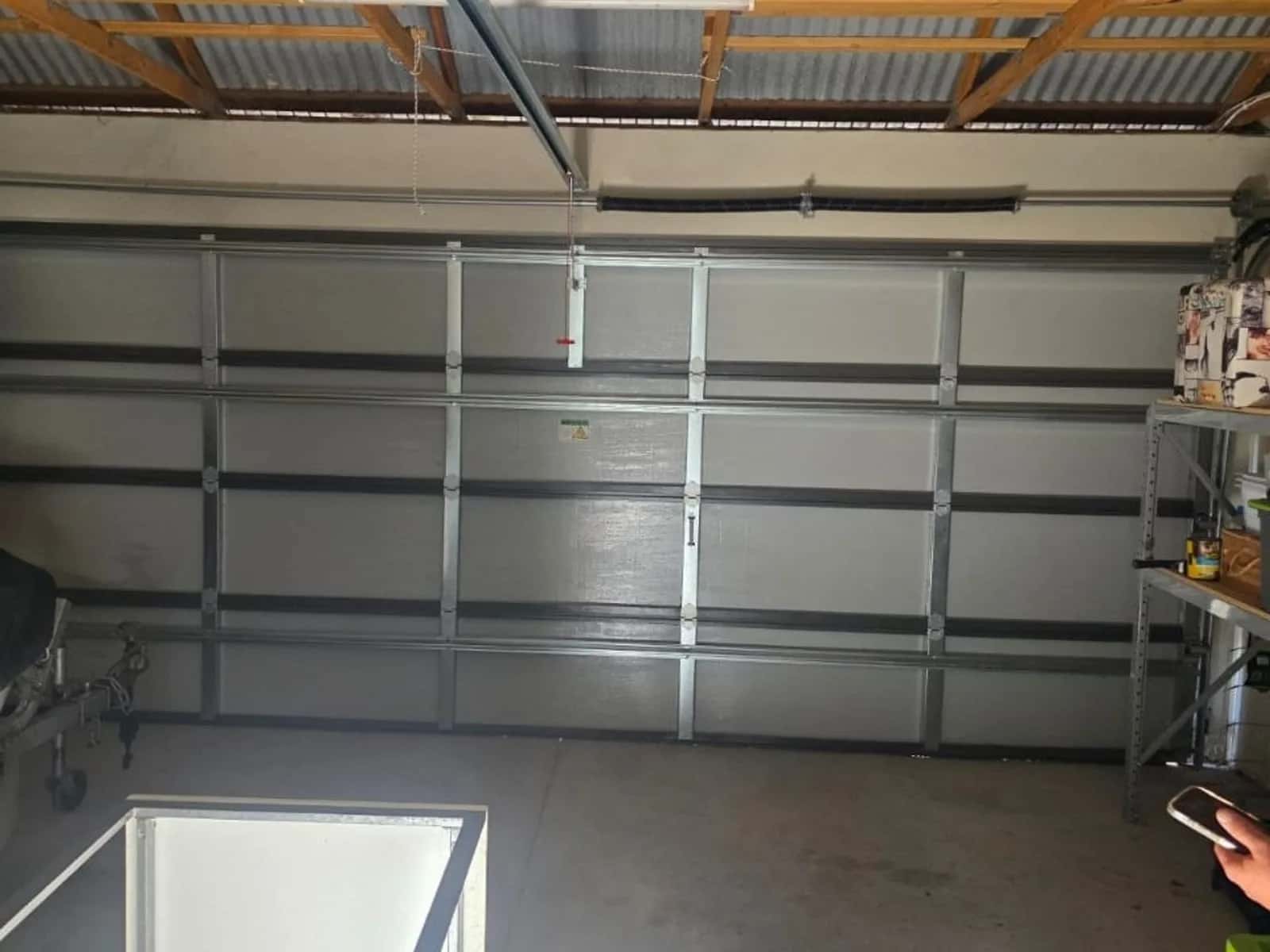 Superlift garage door opener and drive rail fitted under a garage ceiling above a sectional door