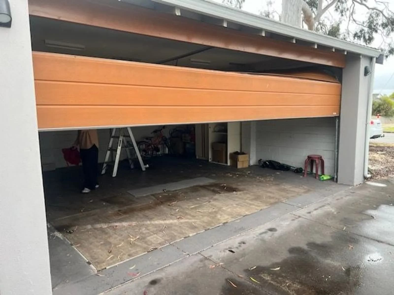 Timber-look sectional garage door hanging crooked in its tracks