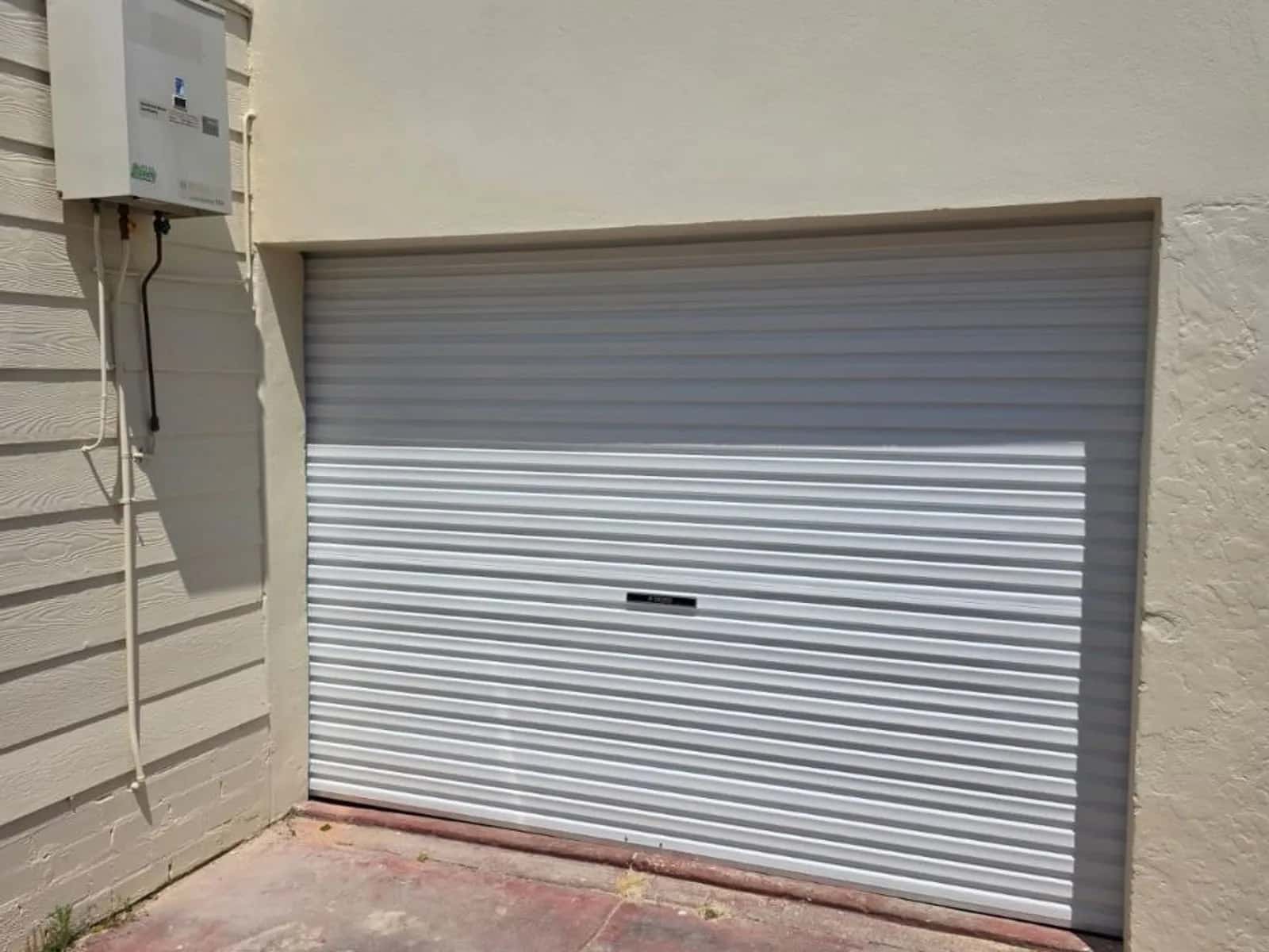 White roller door in a rendered garage wall on a Willetton home
