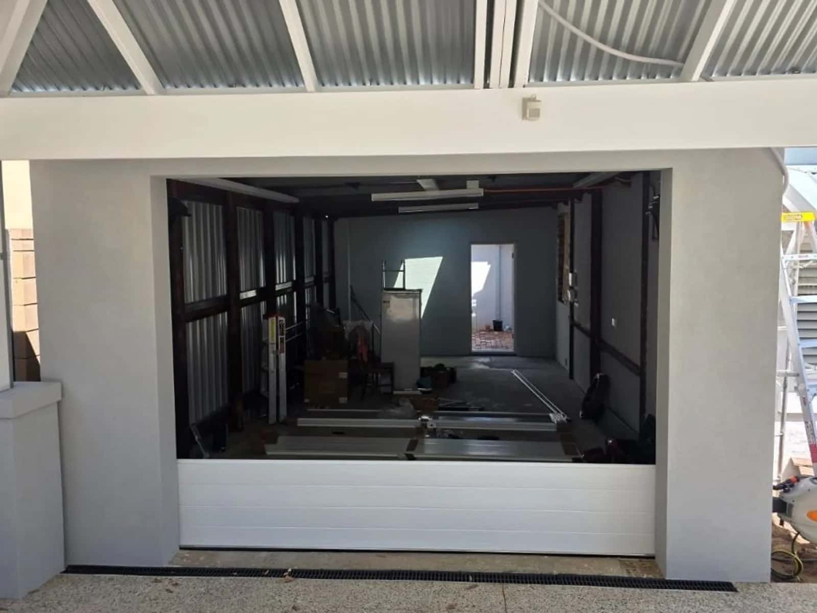 White sectional garage door on a newly built home, closed and sitting square in its opening