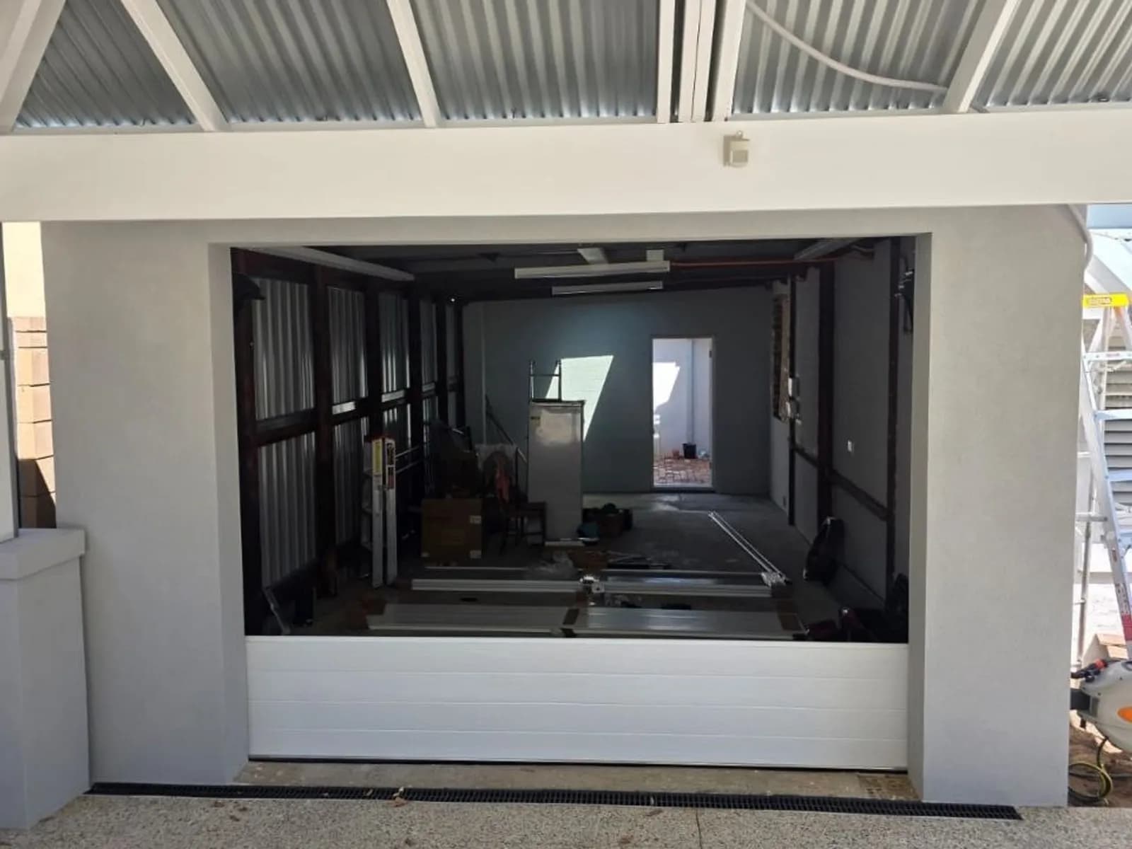 White sectional garage door on a newly built home, closed and sitting square in its opening White sectional garage door on a newly built home, closed and sitting square in its opening